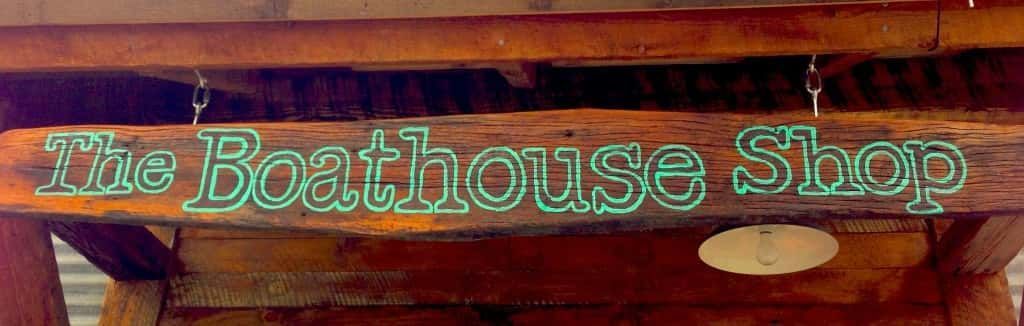 Wooden Sign that Says the Boathouse Shop on It