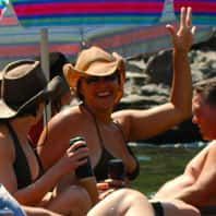 Goup of People Are Sitting Under an Umbrella in The River