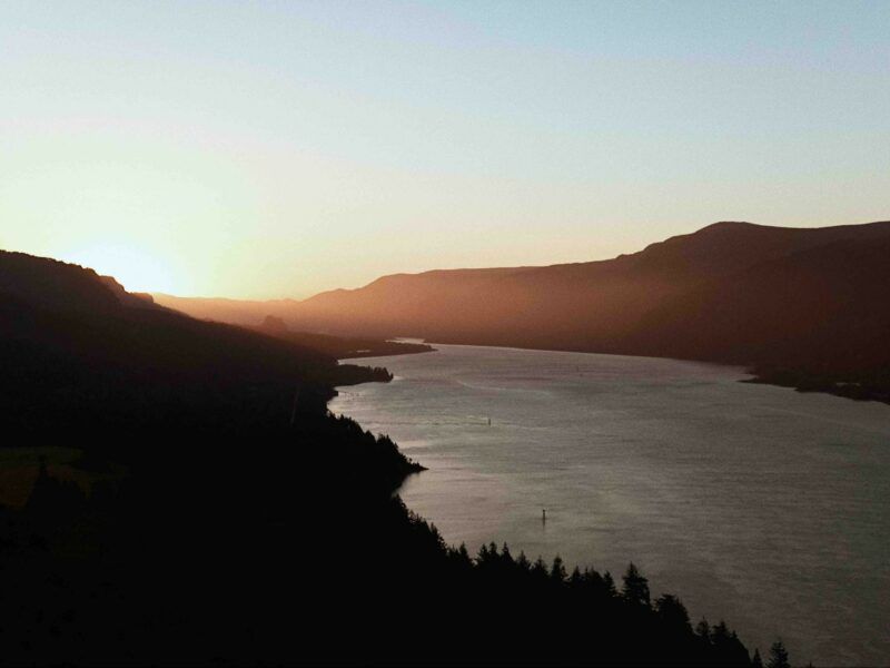 Aerial View of A River Surrounded by Mountains at Sunset