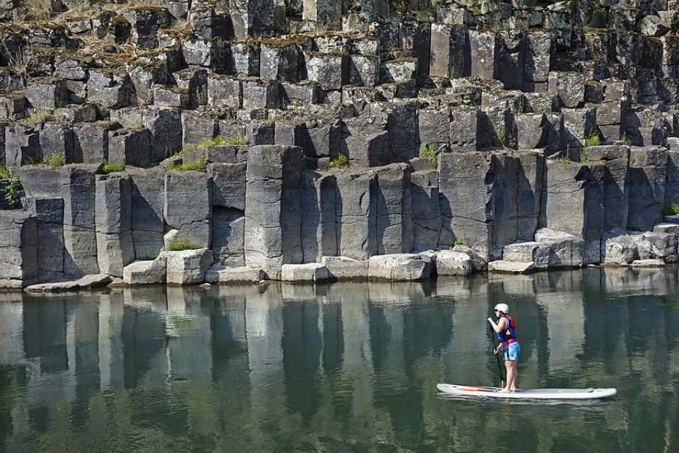 Person Standing on A Paddle Board in A Lake