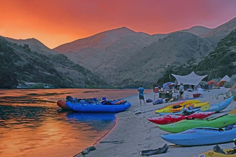 Row of Kayaks Lined up On the Shore of A River