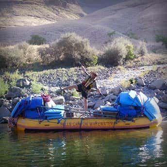 A Man Is Standing on A Raft in The Water