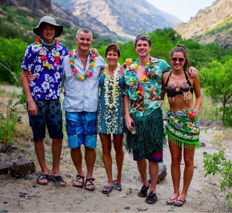 A group of people posing for a picture with mountains in the background