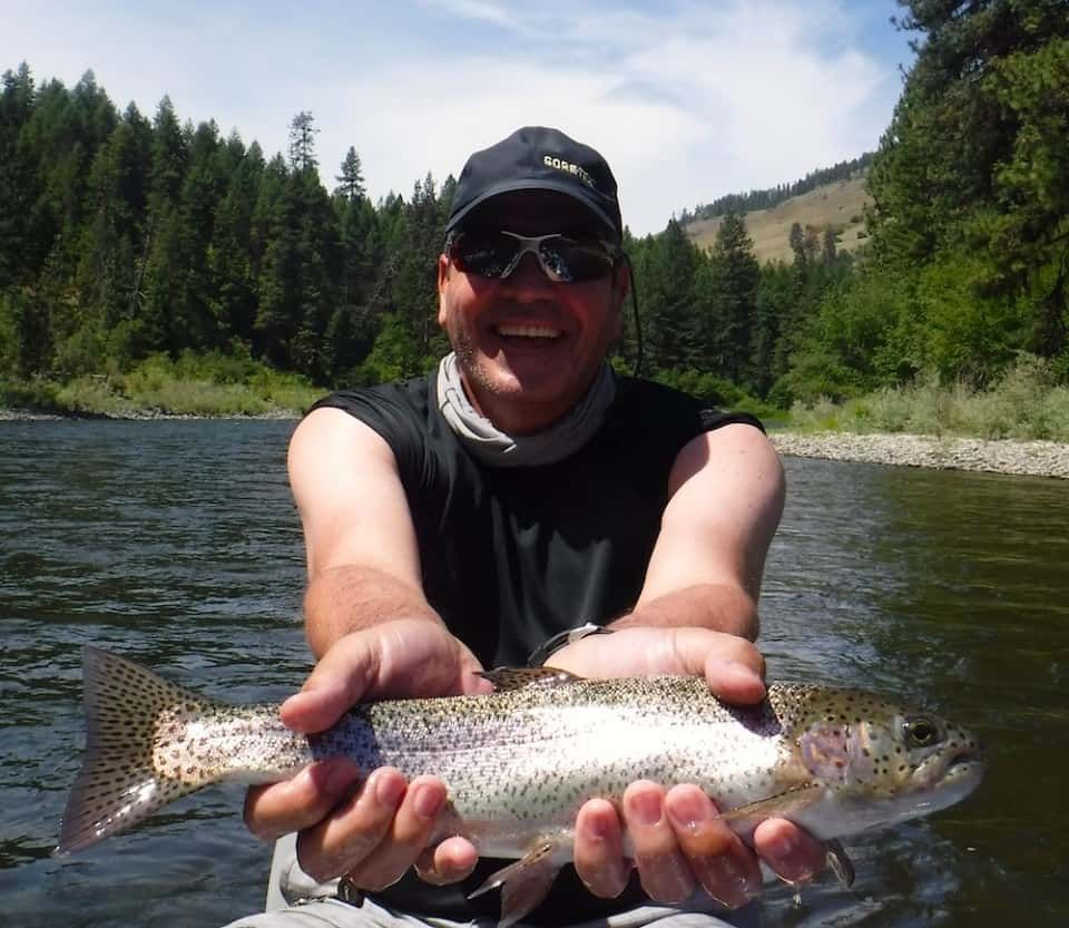 Man holding a rainbow trout in his hands