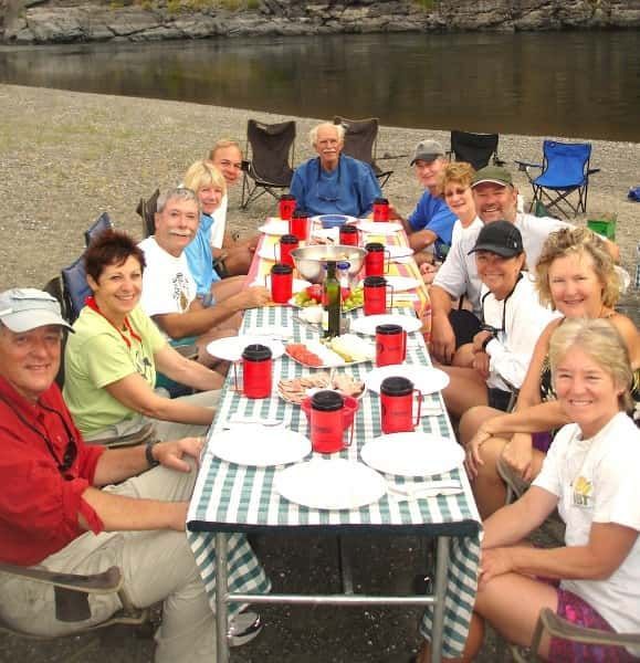 People Sitting Around a Table with Plates and Cups