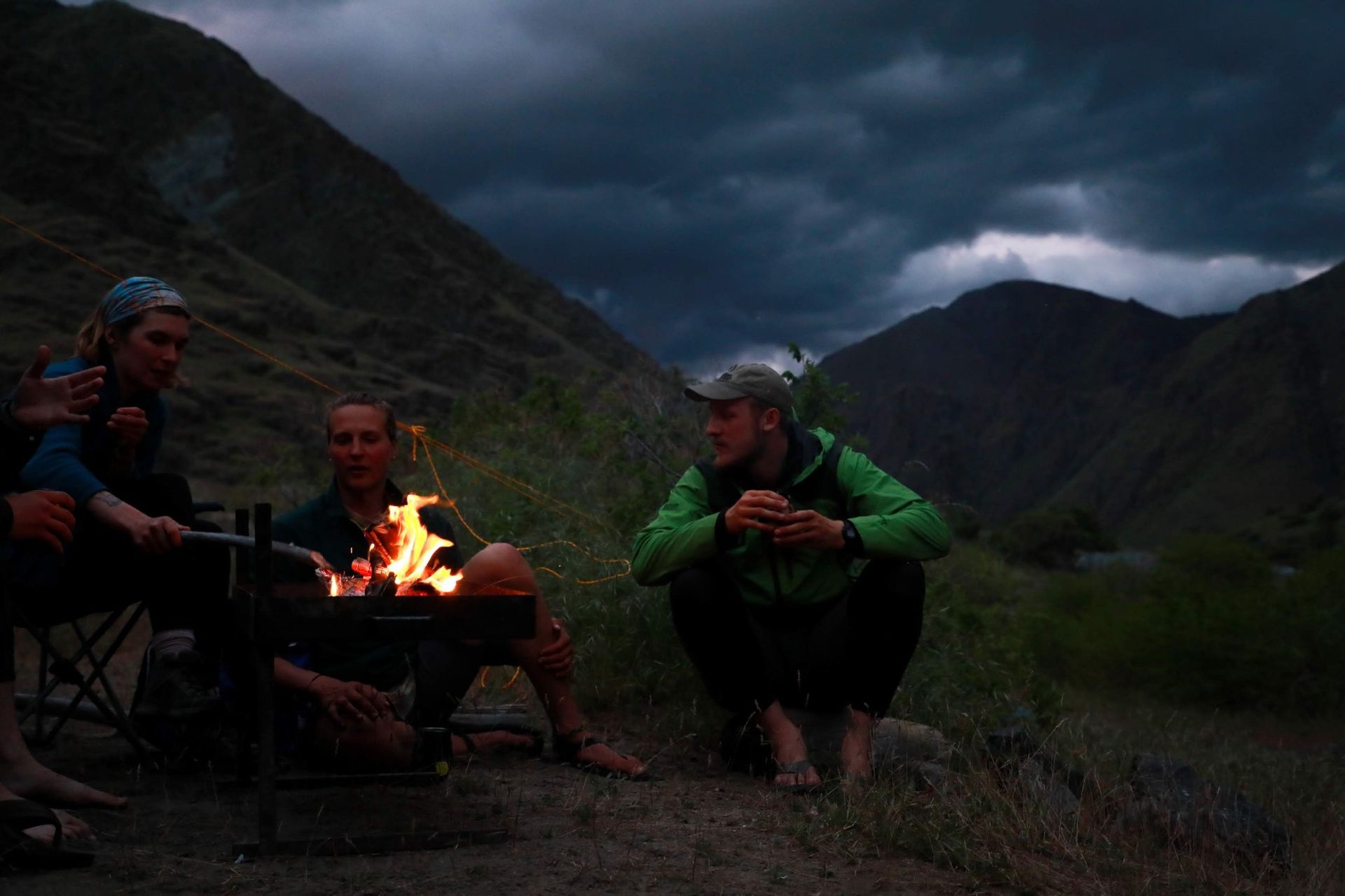 Group of People Are Sitting Around a Campfire in the Mountains