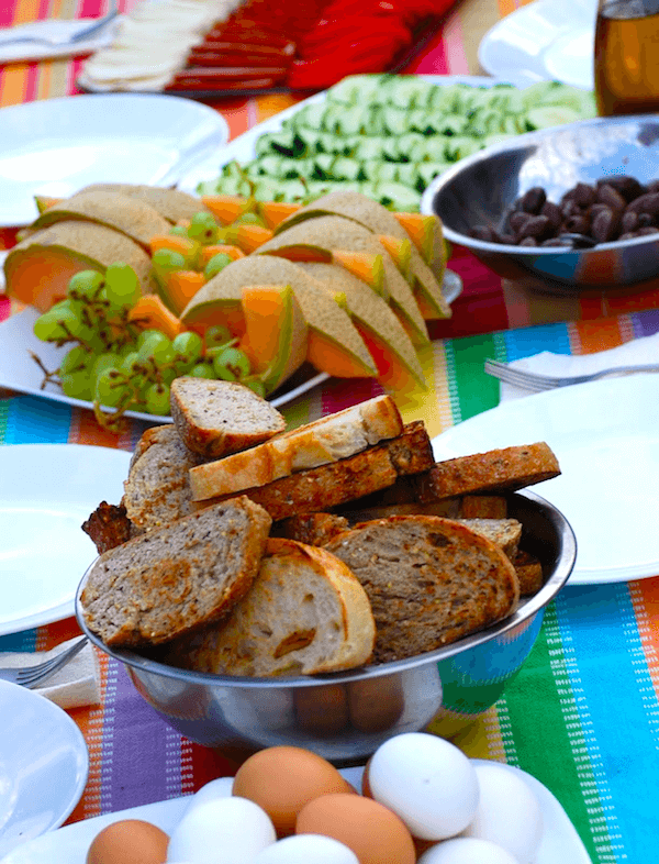 A bowl of bread sits on a table next to eggs