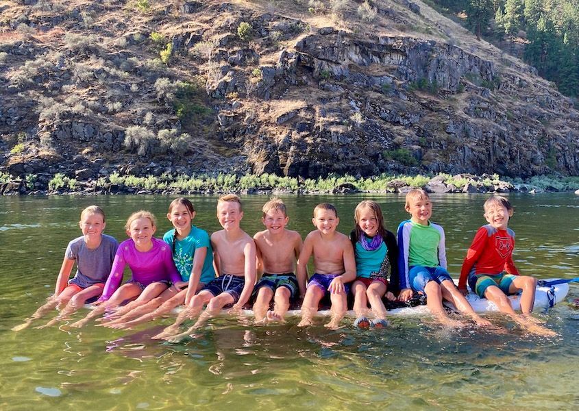 Group of Children Sitting on A Raft in the Water