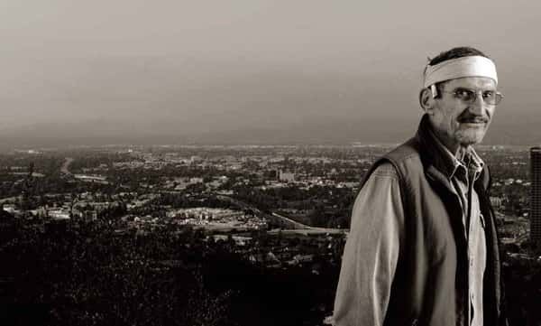 A Man Wearing a Headband Is Standing in Front of A City