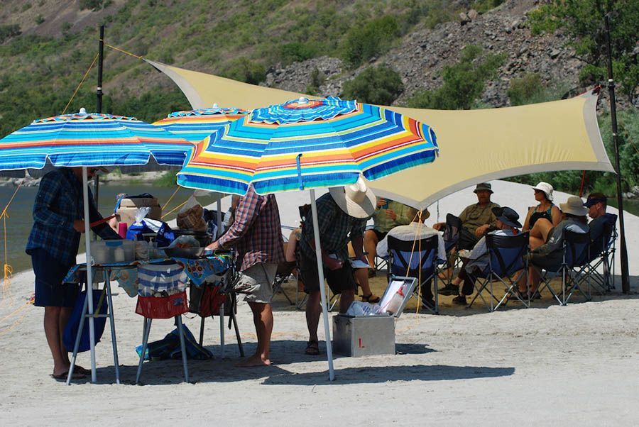 People Sitting Under Umbrellas on A Beach