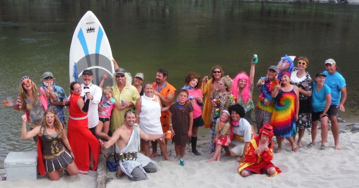 Group of People Posing for A Picture with A Paddle Board in The Background