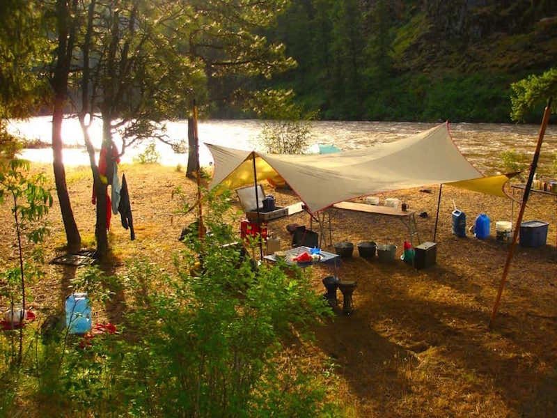 A Tent Set up in the Woods Near a River