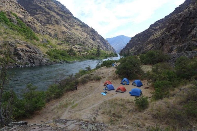 Group of tents are sitting on the side of a river