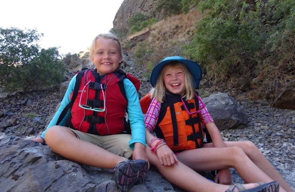 Two Kids Sitting on A Rock