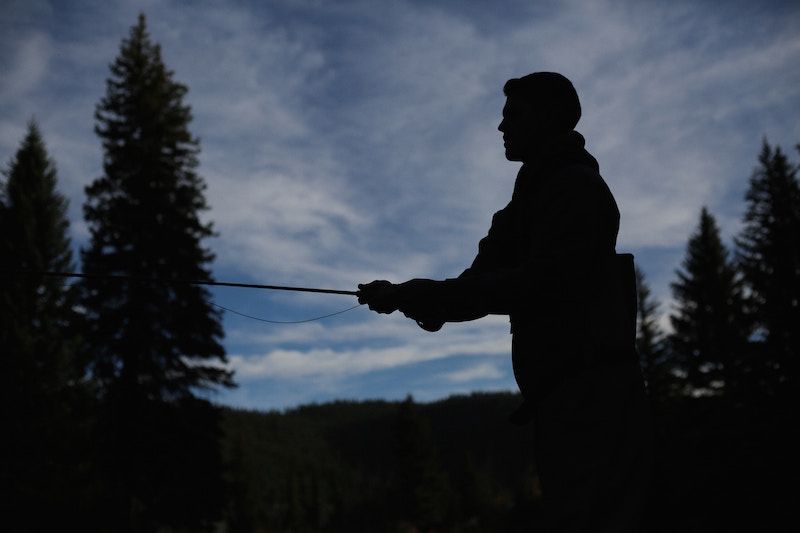 Silhouette of A Man Holding a Fishing Rod