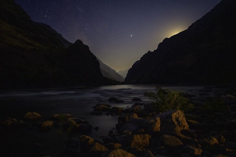 People along the river bank at night