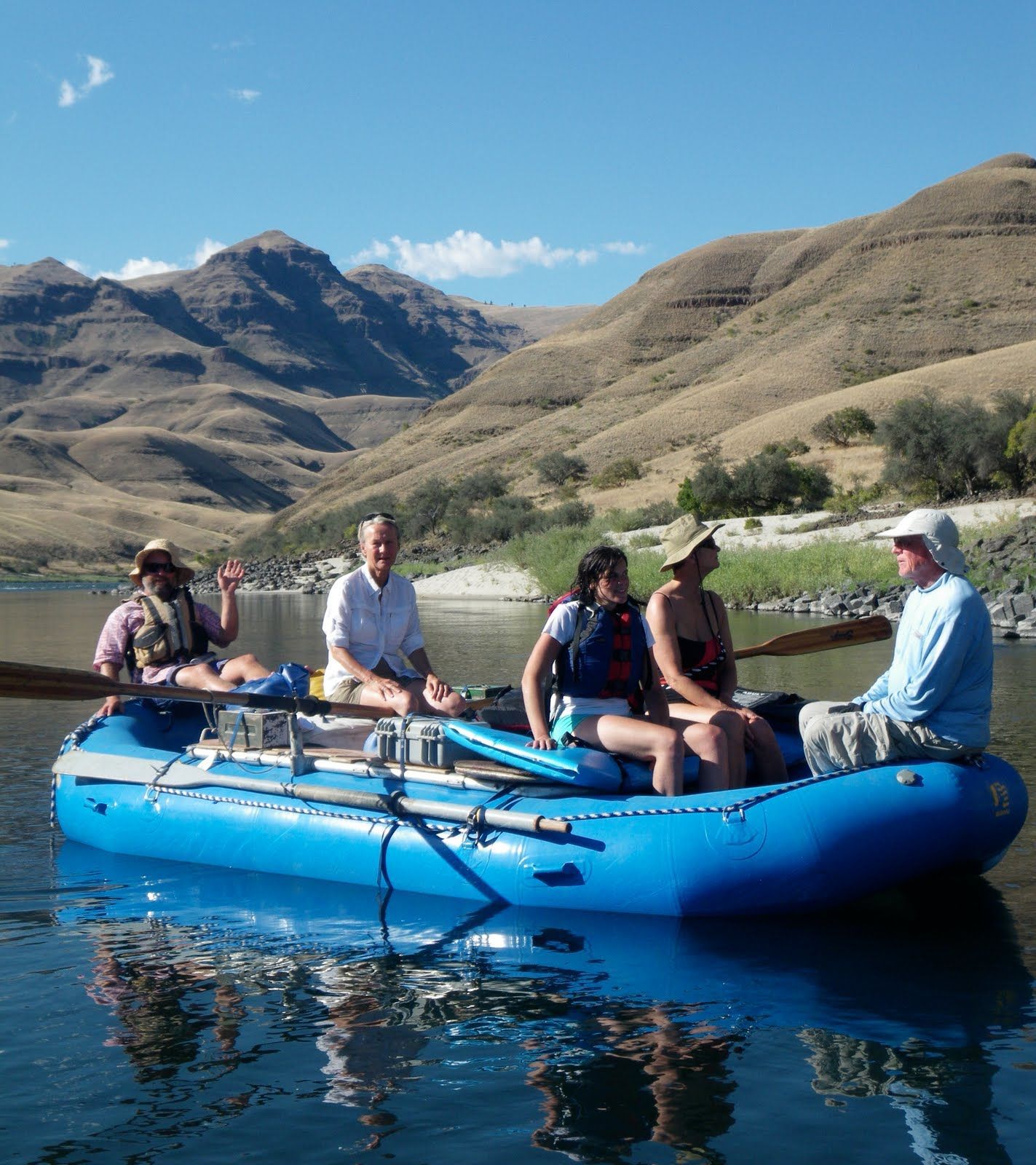 A group of people are in a blue raft on a lake