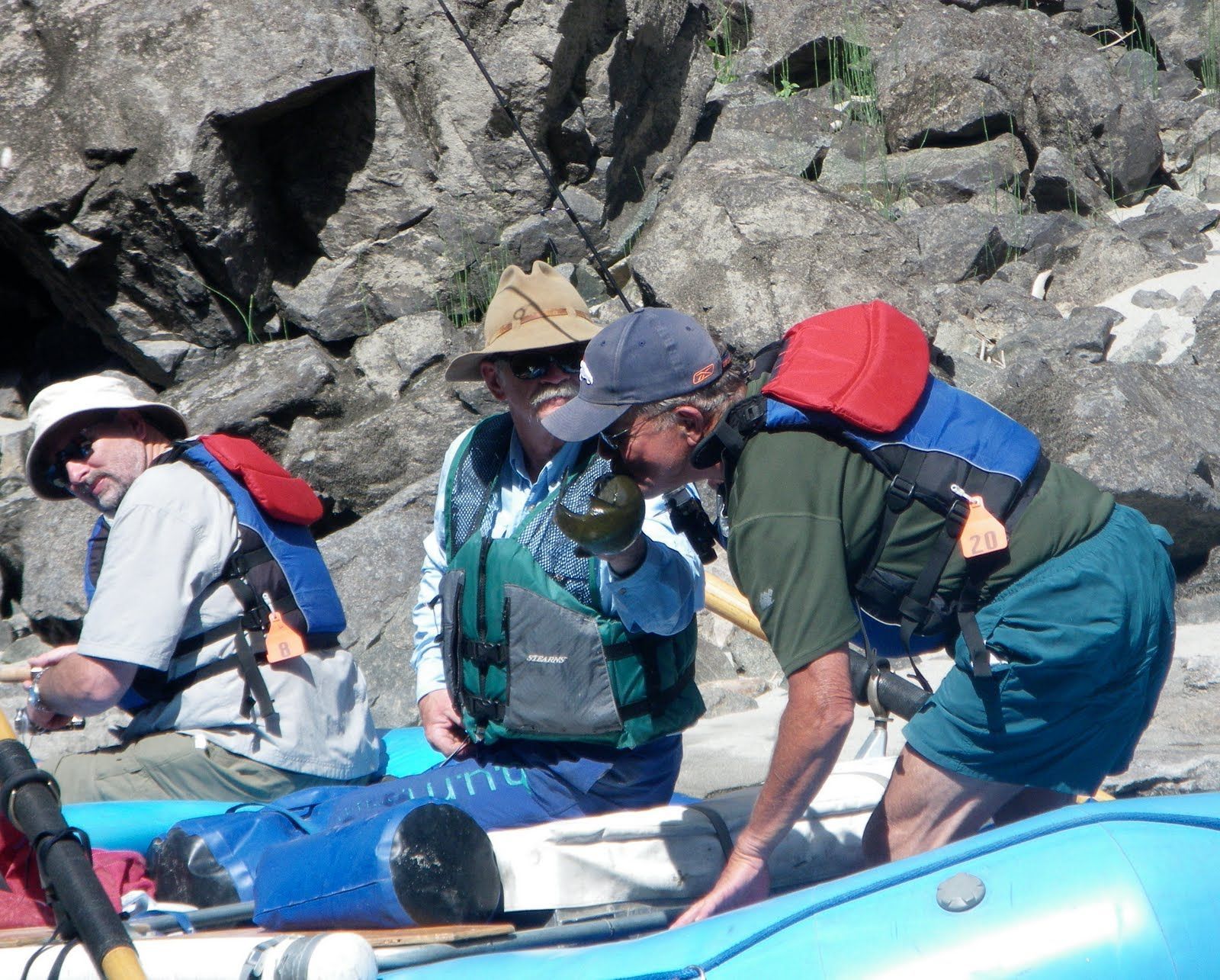 A group of men are sitting in a raft on a river