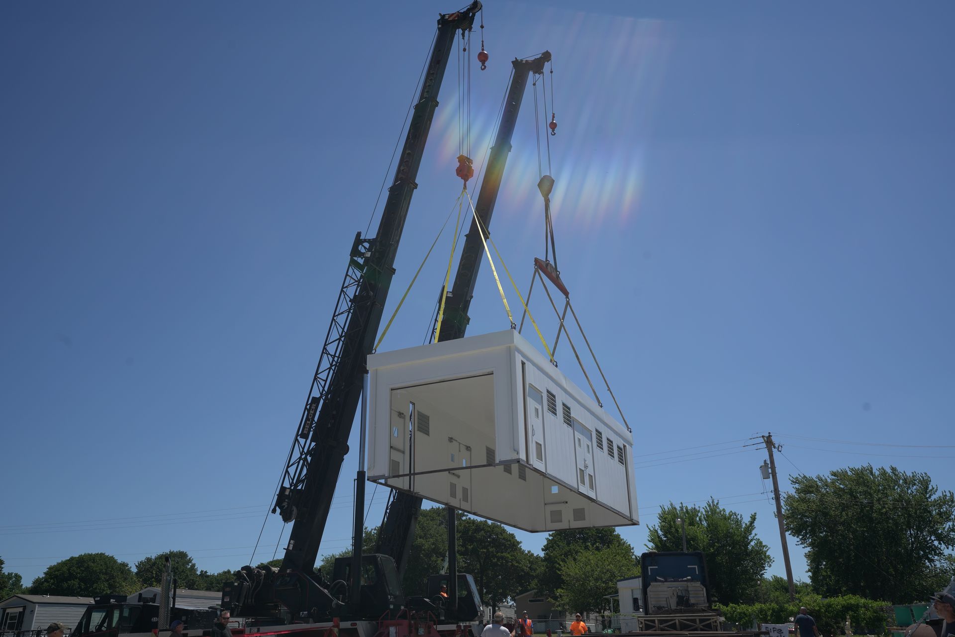A large white building is being lifted by a crane.