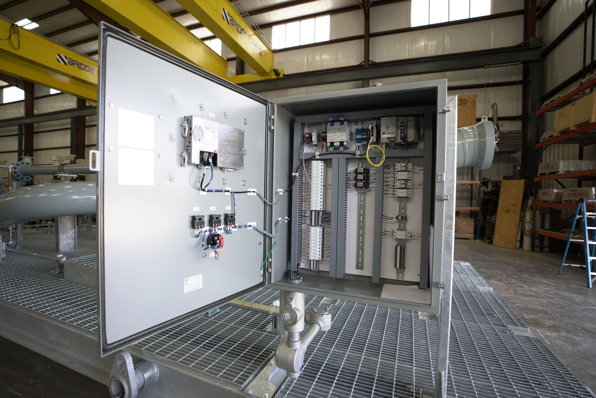 A large electrical box is sitting in a warehouse with the door open.