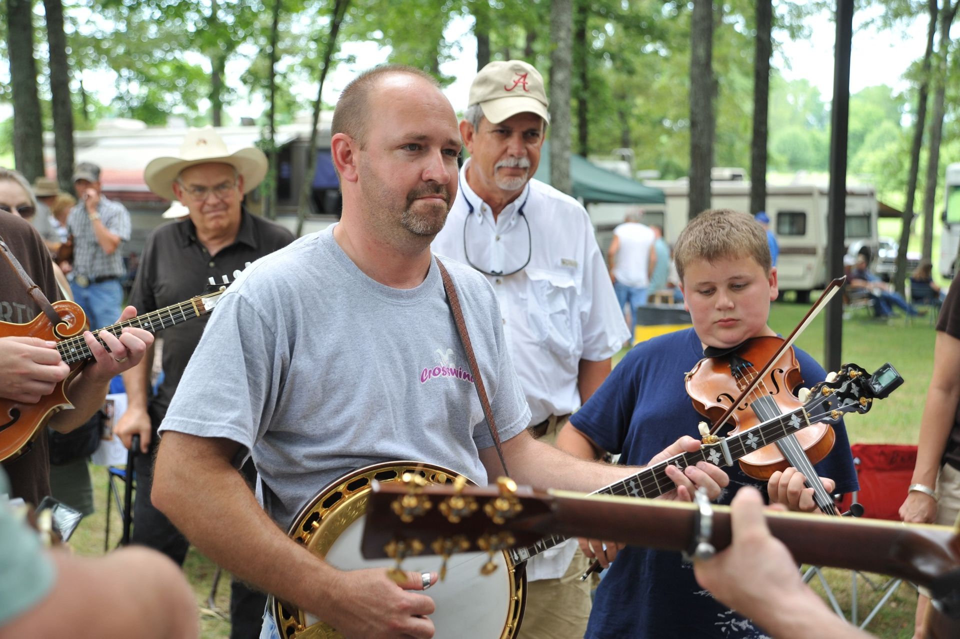 A man playing a banjo and a boy playing a violin