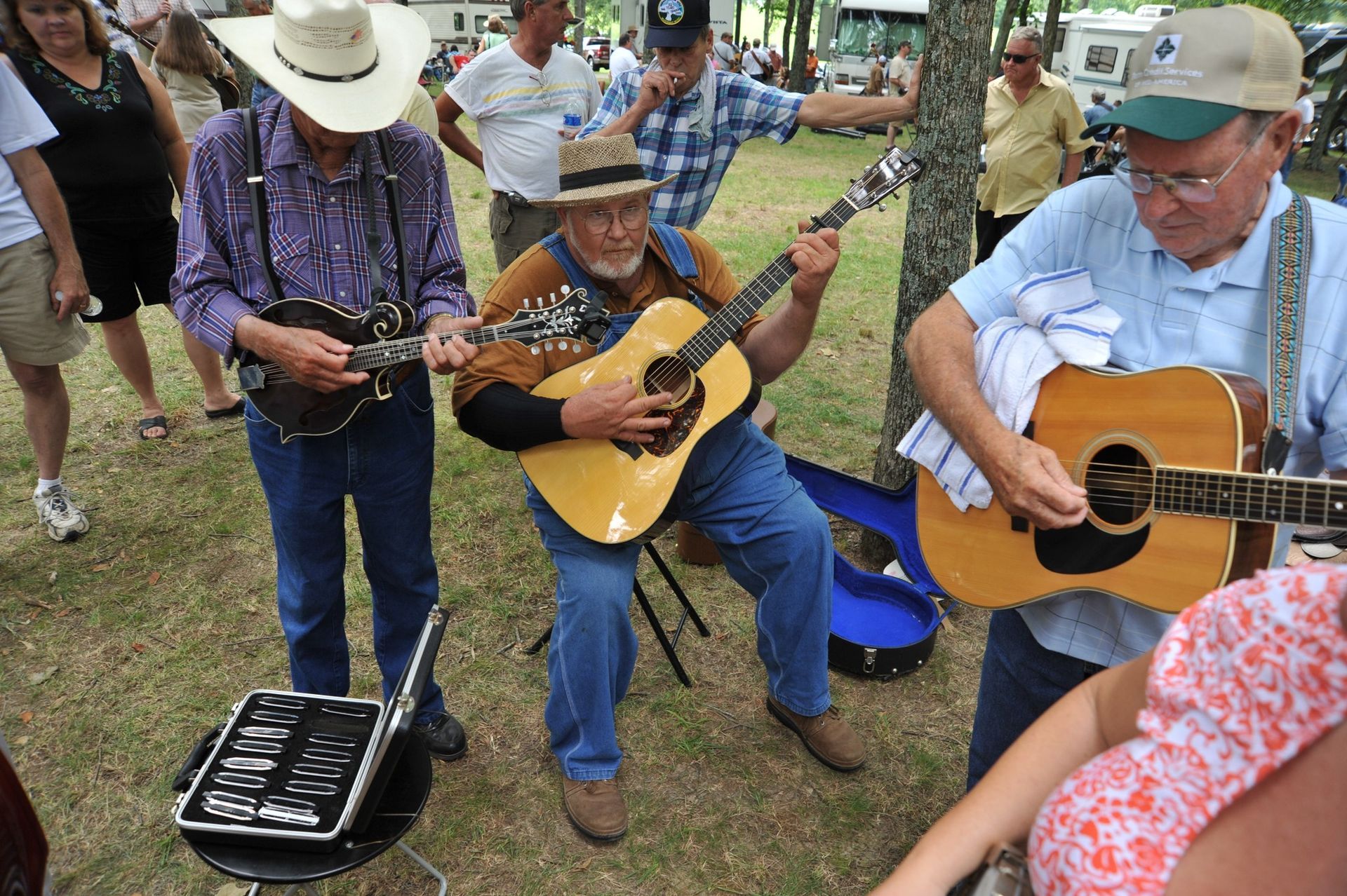 A group of men are playing guitars in a park