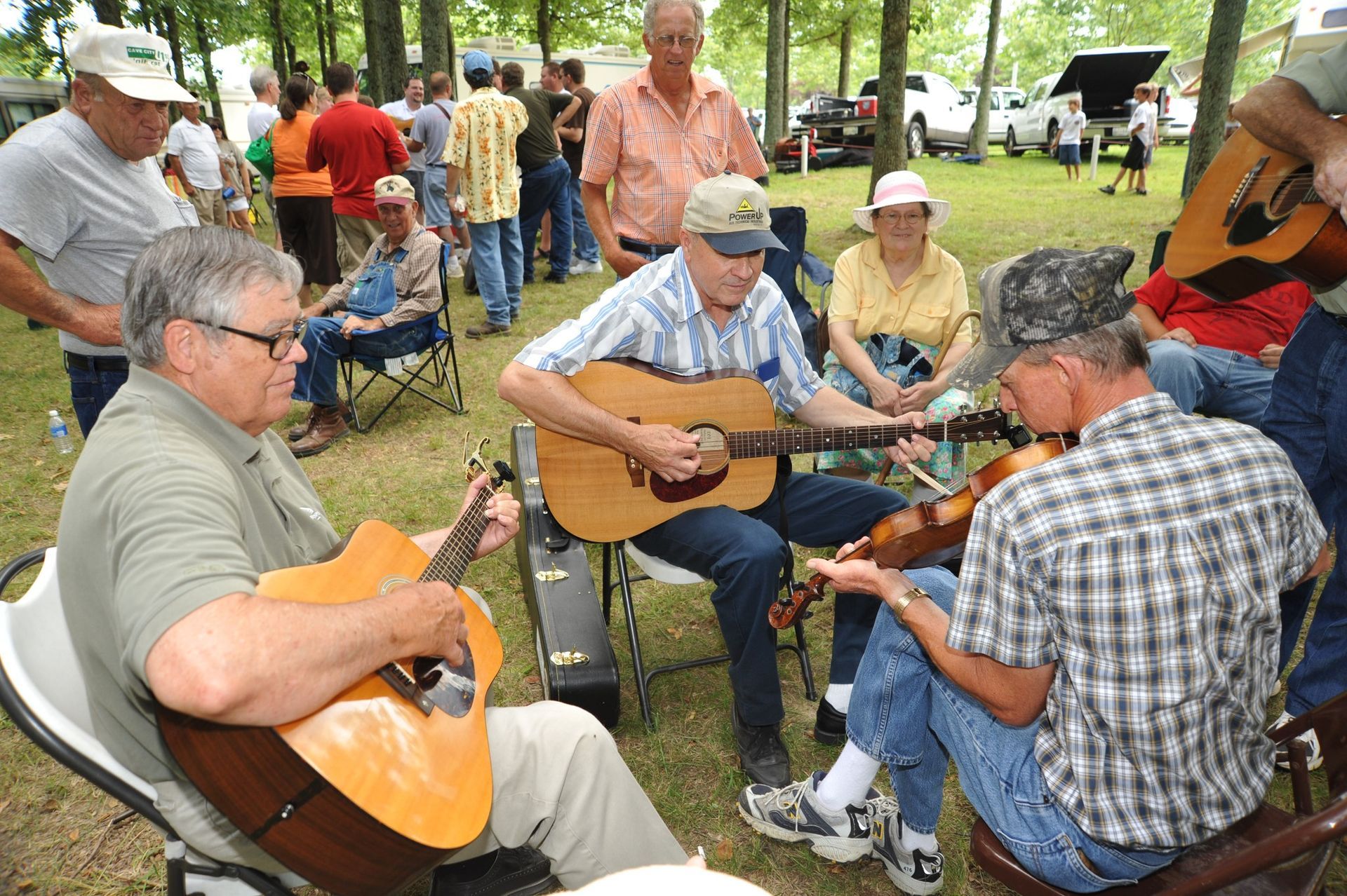 A group of men are playing guitars in a park