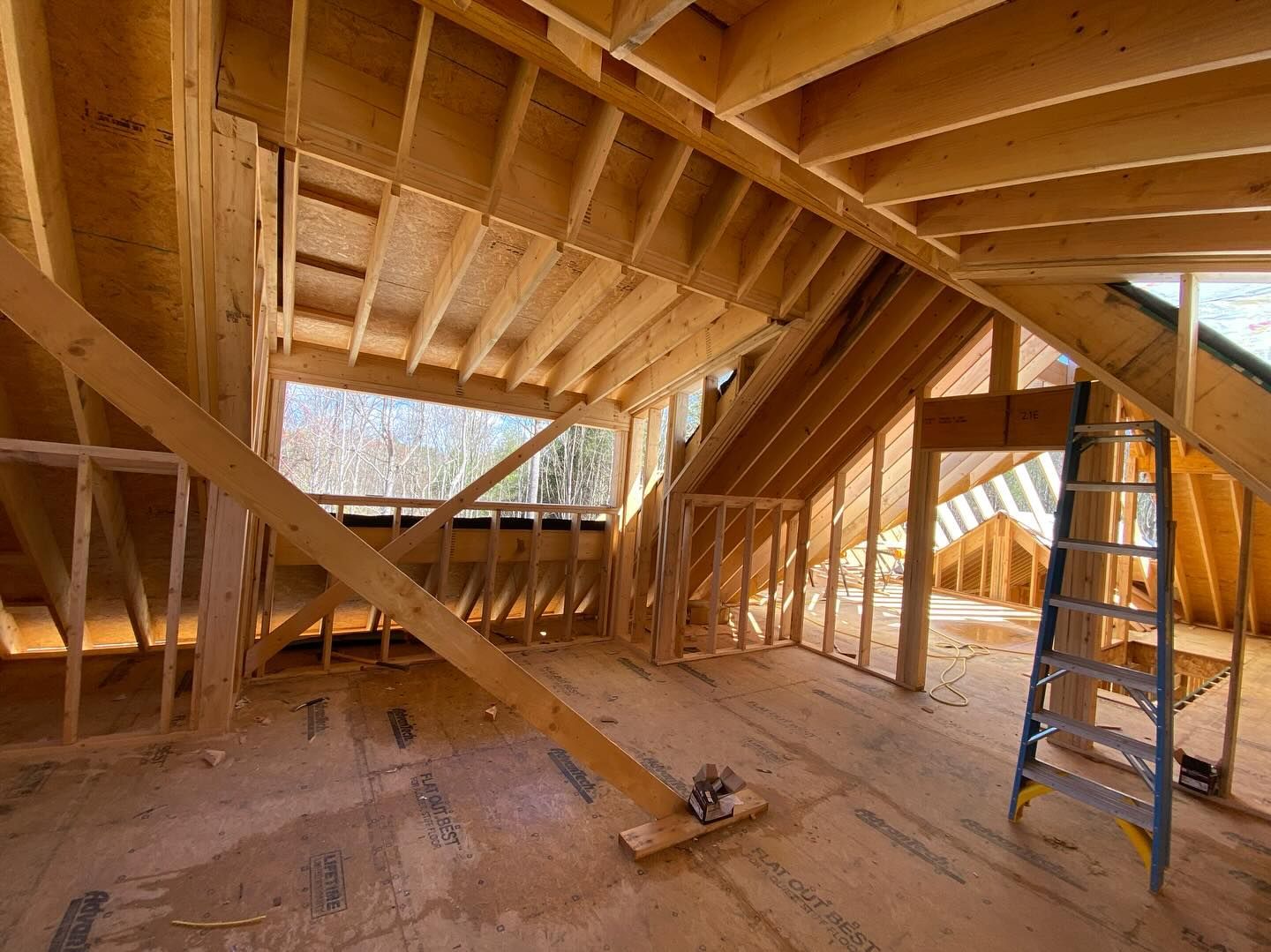 Interior framing of a house under construction; wooden beams and studs.