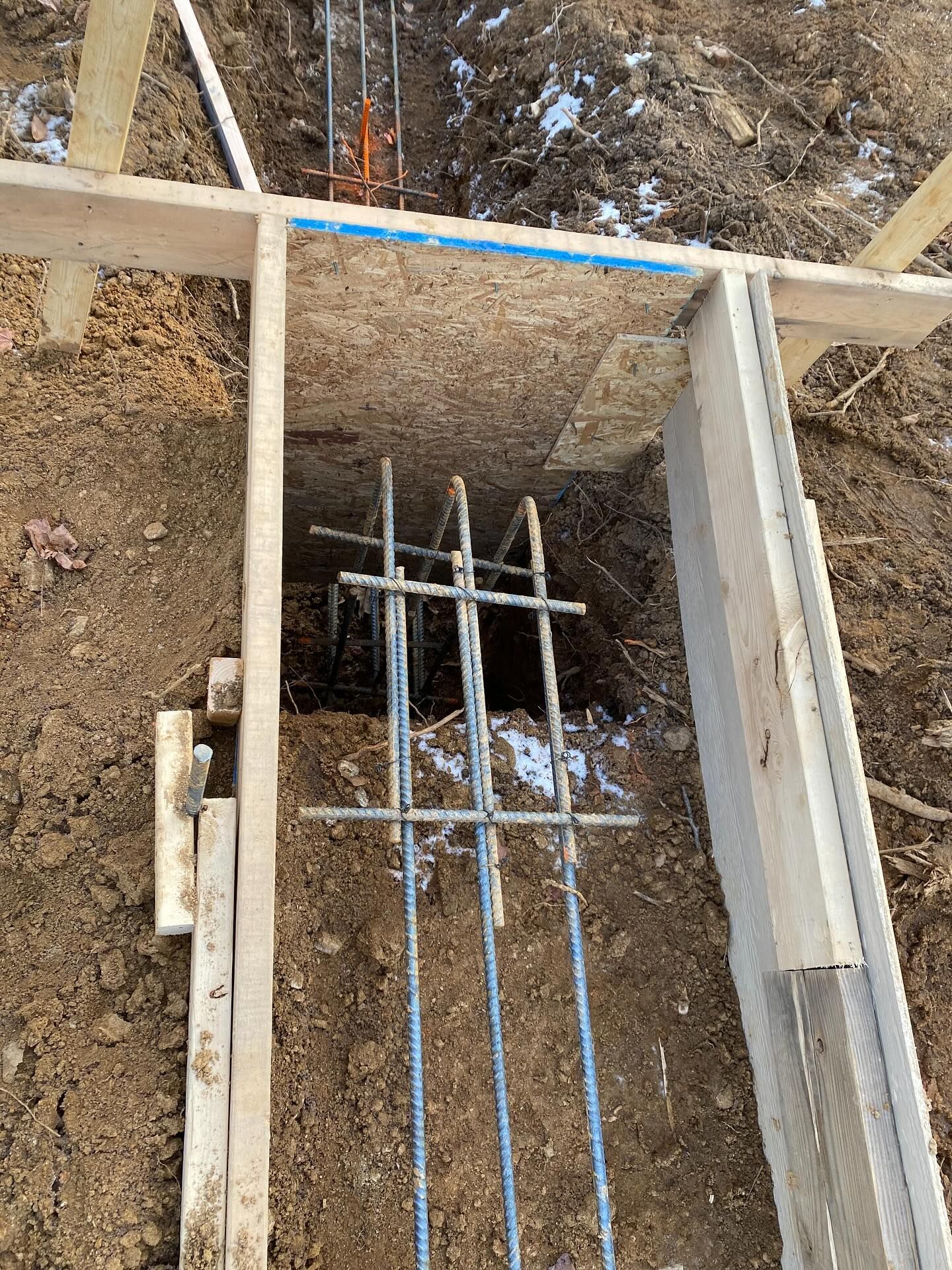 Foundation formwork with rebar in a trench, ready for concrete.