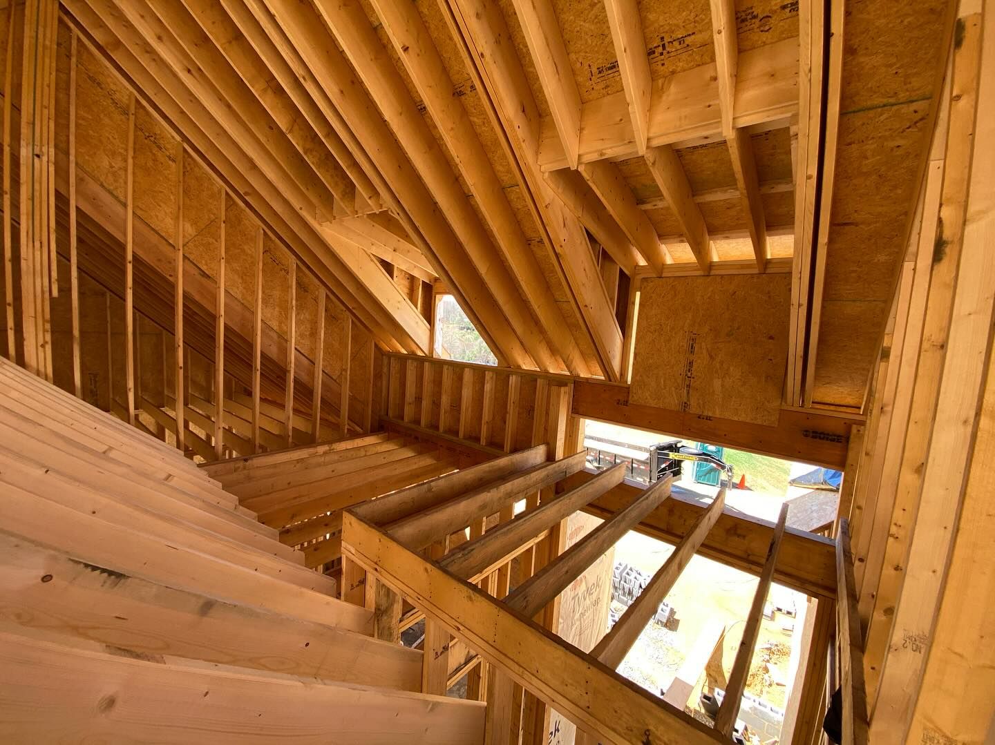 Interior view of a wood-framed staircase under construction, leading to a second level.