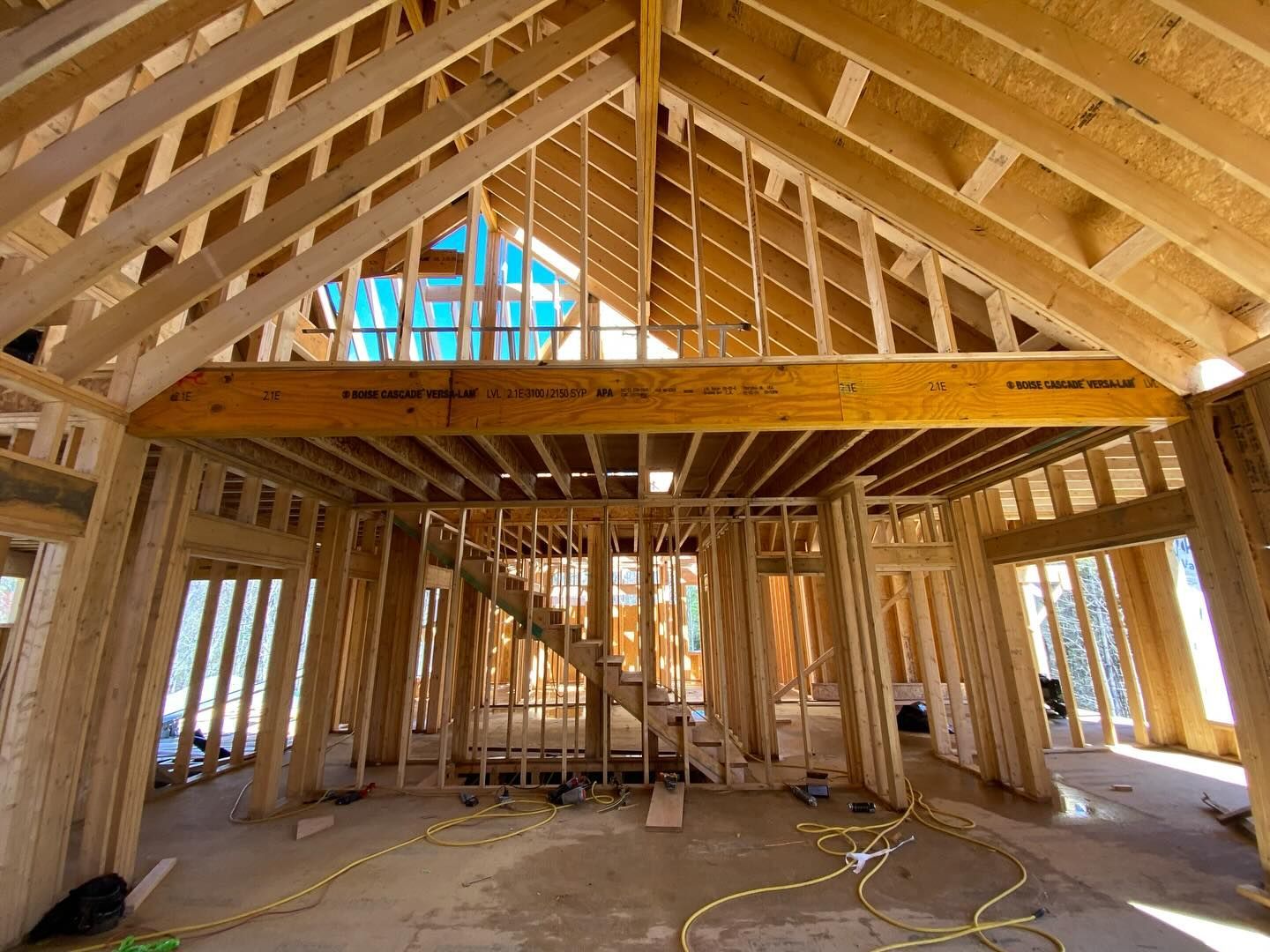 Interior of a building under construction, wooden framework with a high ceiling and exposed beams.