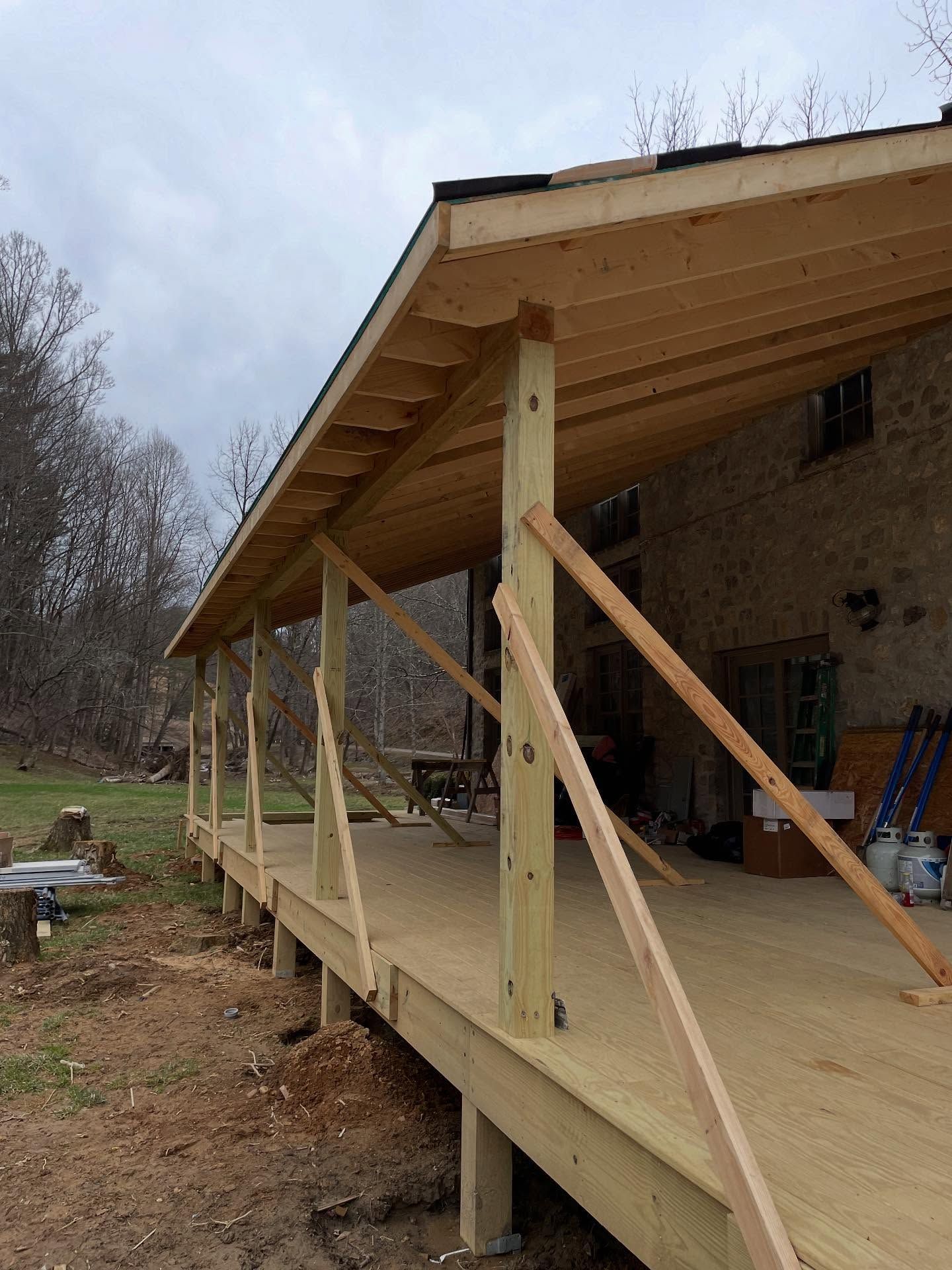 Wooden porch under construction; deck, roof, and posts visible.