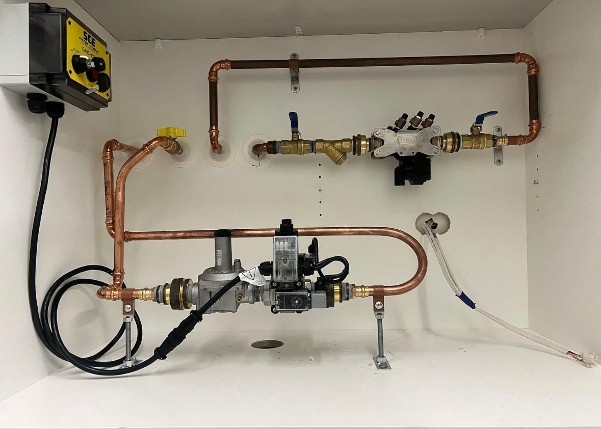 Pressure washer cleaning a concrete driveway; garage, trash cans in background.