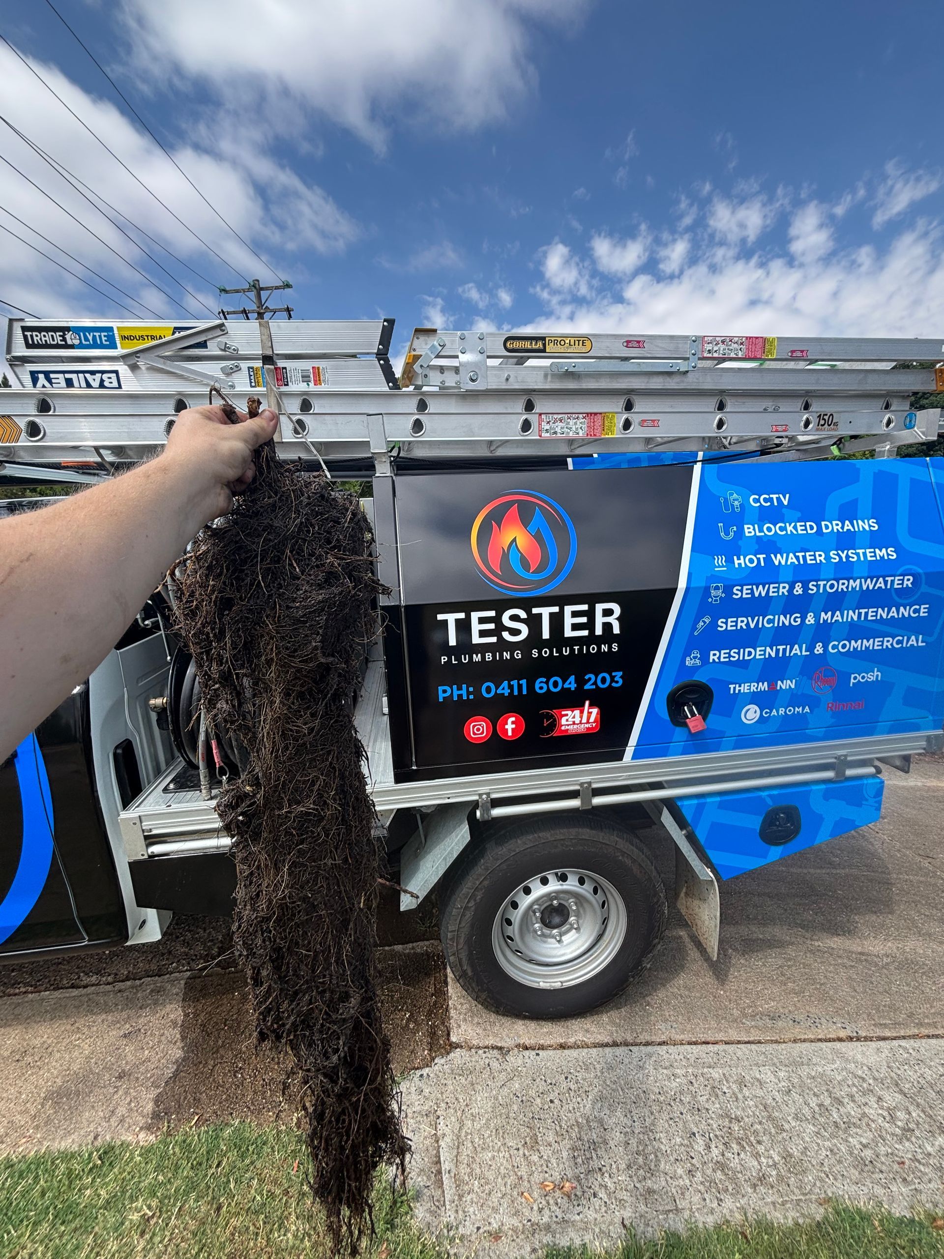 Hand holding a sooty chimney brush; a service truck with the name 
