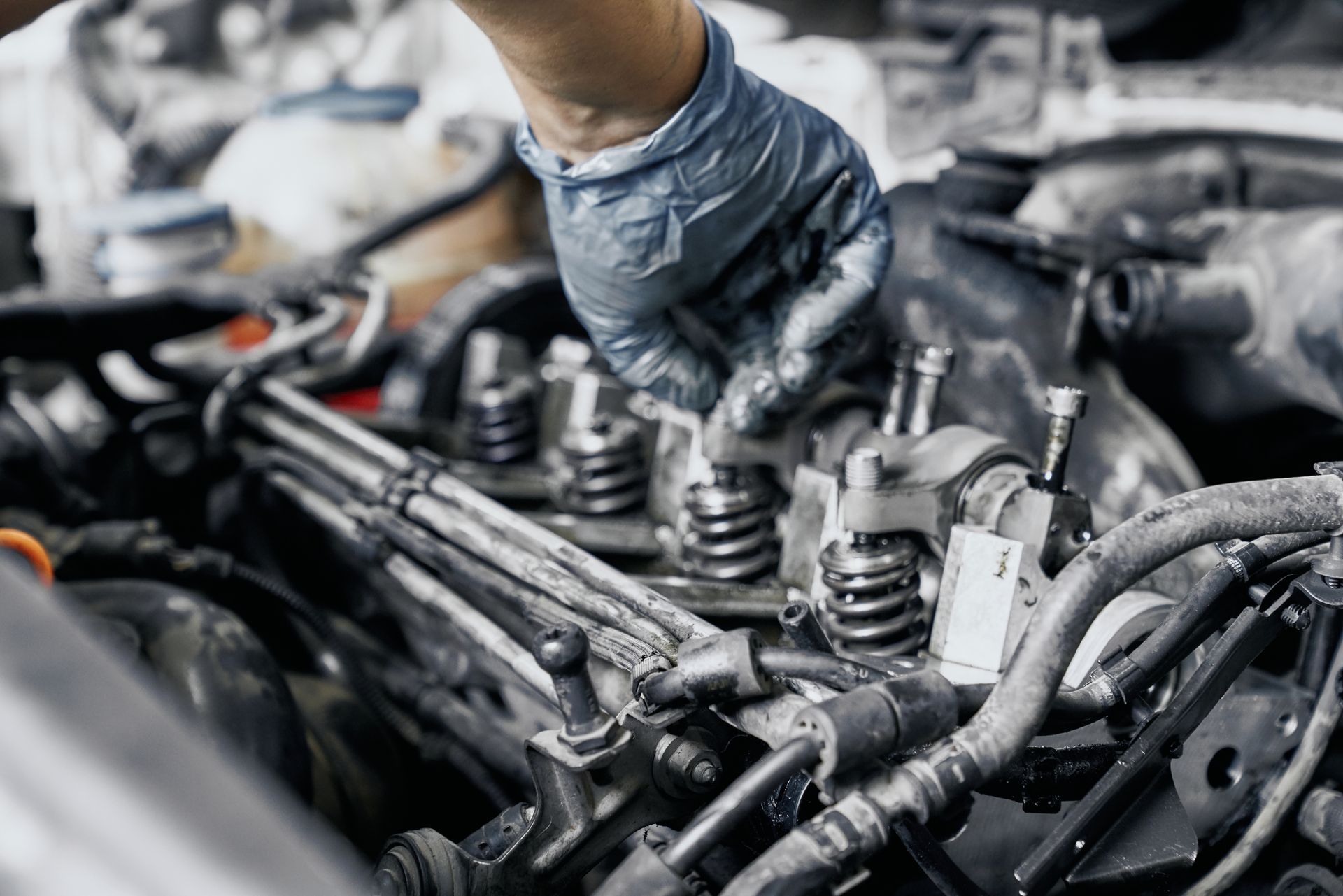 A close up of a person working on a car engine.