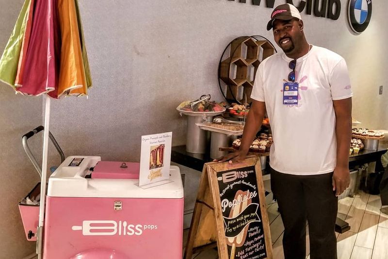 A man standing next to a pink bliss cooler