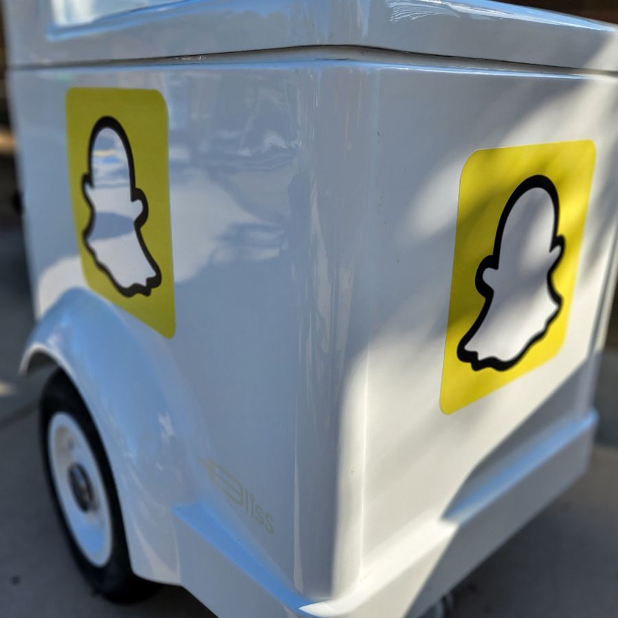 A white vehicle with two snapchat stickers on the side