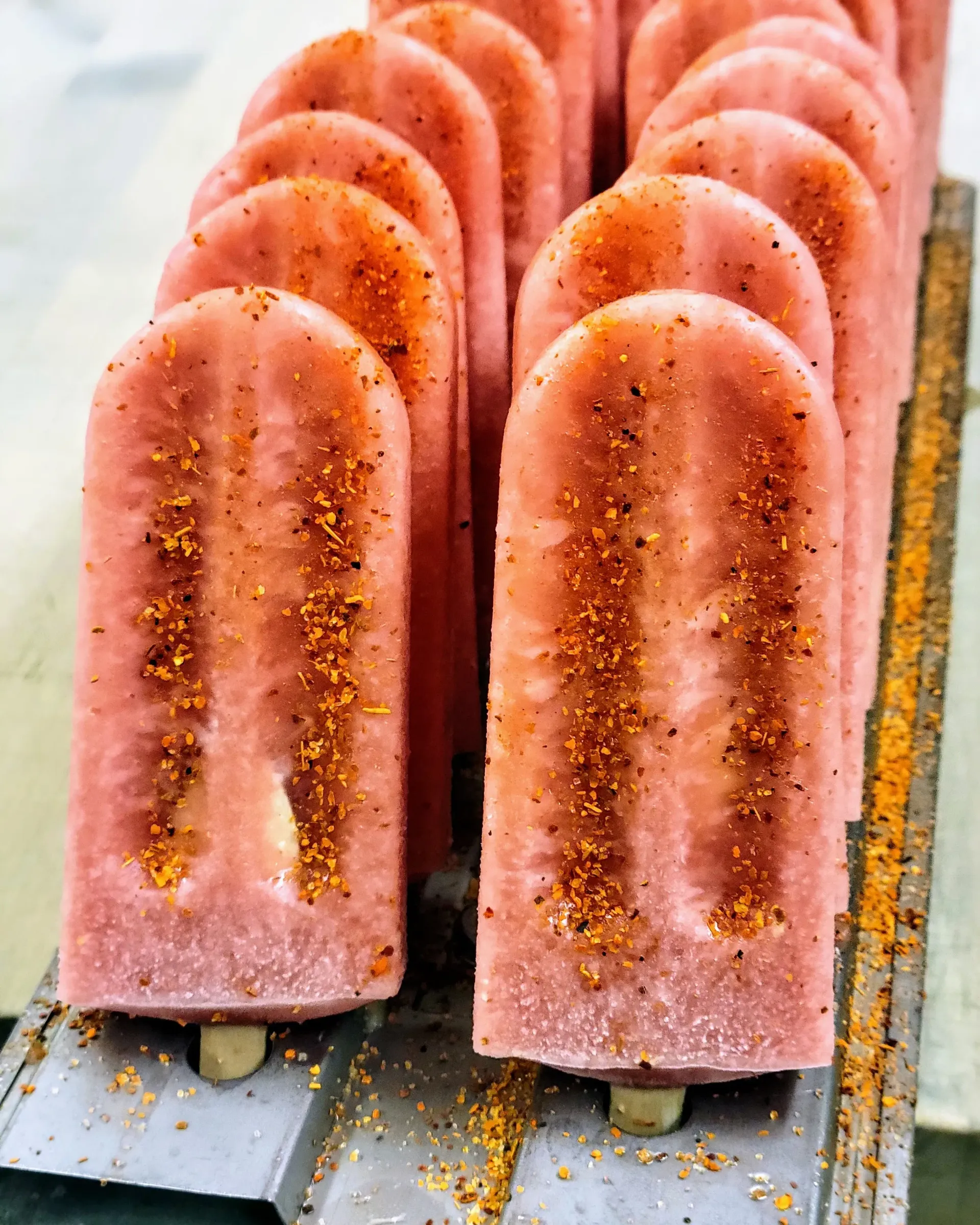 A row of blue popsicles are sitting on a table.