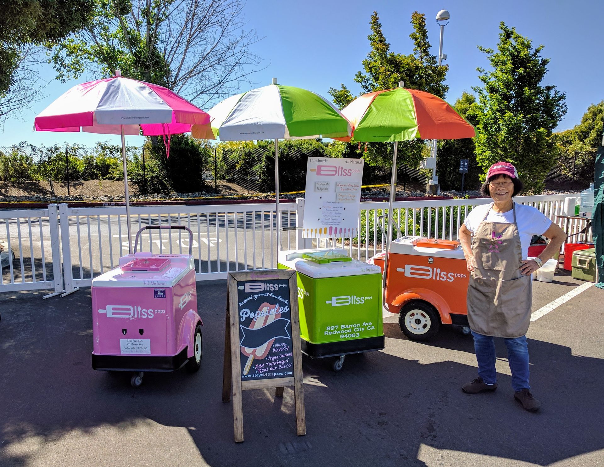 A woman is standing in front of a row of ice cream carts.