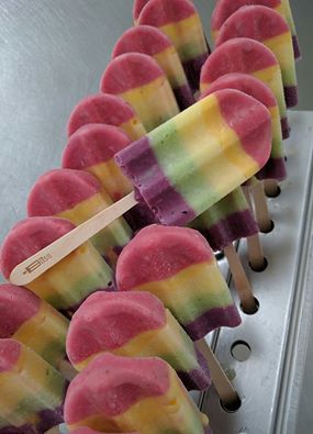 A row of blue popsicles are sitting on a table.