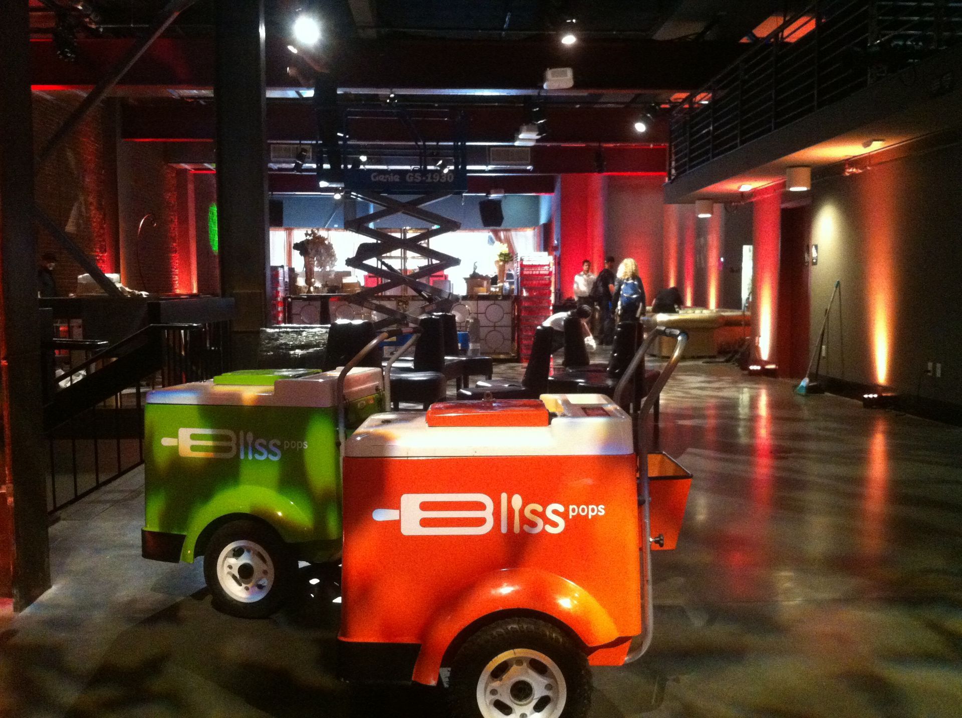 A green bliss vehicle is parked in a dark room