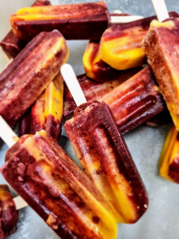 A bunch of chocolate and yellow popsicles on sticks