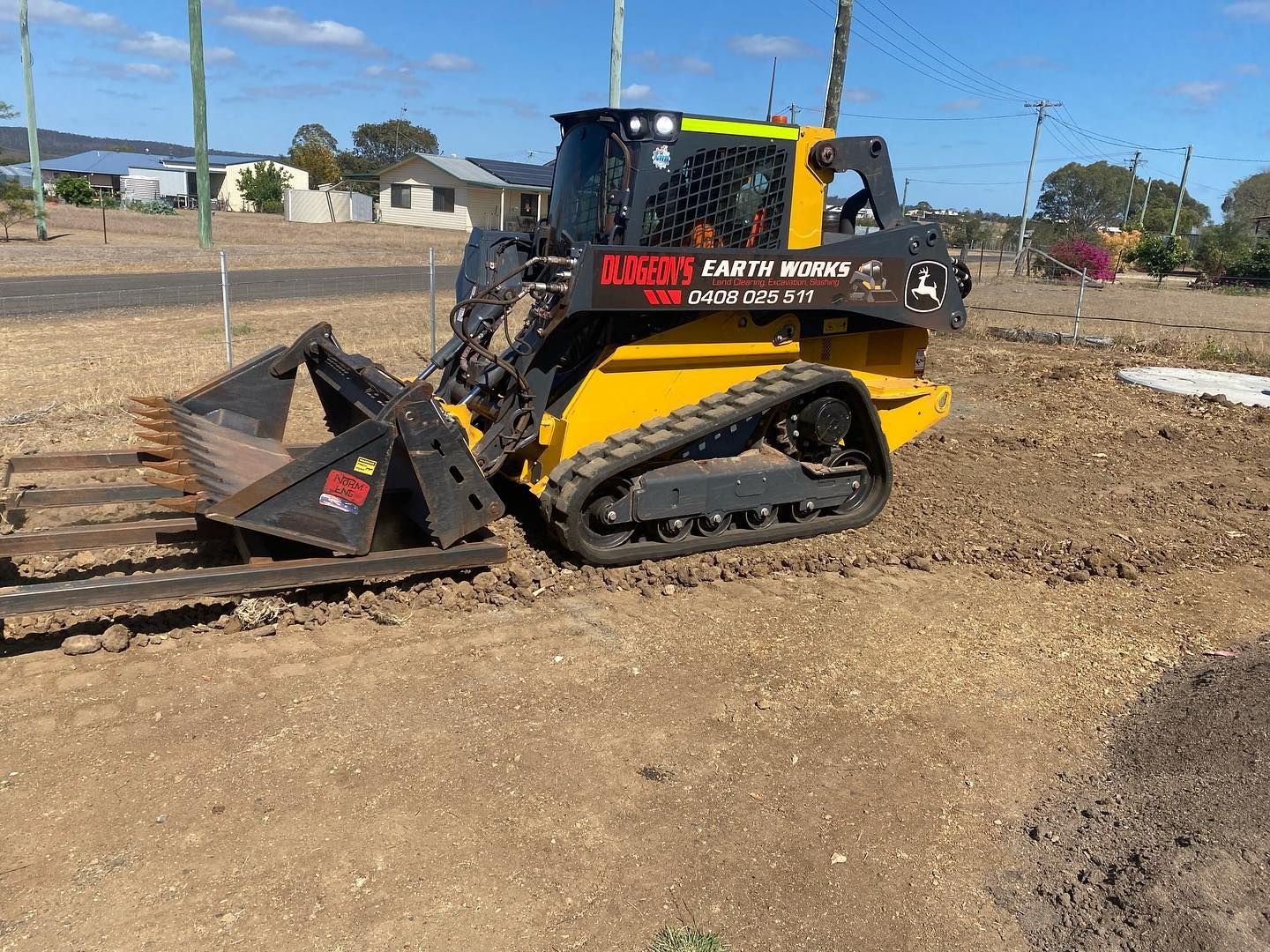 Yellow and Black Track Loader With a Rake Attachment on a Dirt Lot — Dudgeon’s Earthworks in Murgon, QLD