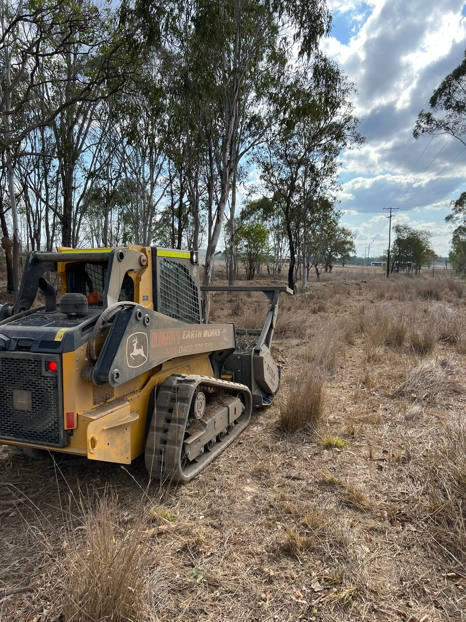 Yellow John Deere Compact Track Loader Clearing Dry Brush in Field — Dudgeon’s Earthworks in Murgon, QLD