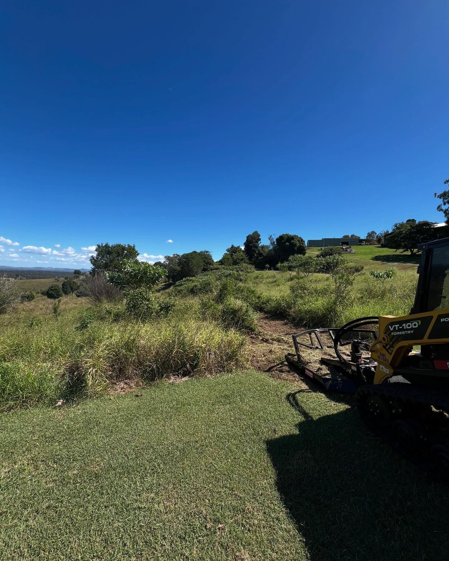 A Utility Vehicle on a Grassy Hill, Clearing a Path Through Overgrown Brush — Dudgeon’s Earthworks in Murgon, QLD