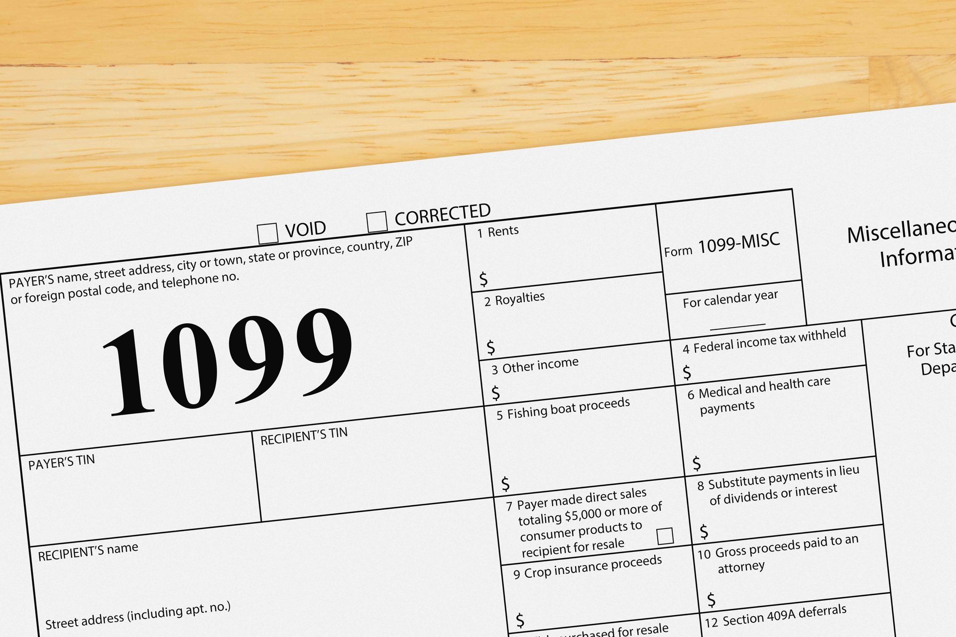 Close-up of a blank 1099 tax form on a wood surface. The form is for miscellaneous income reporting.