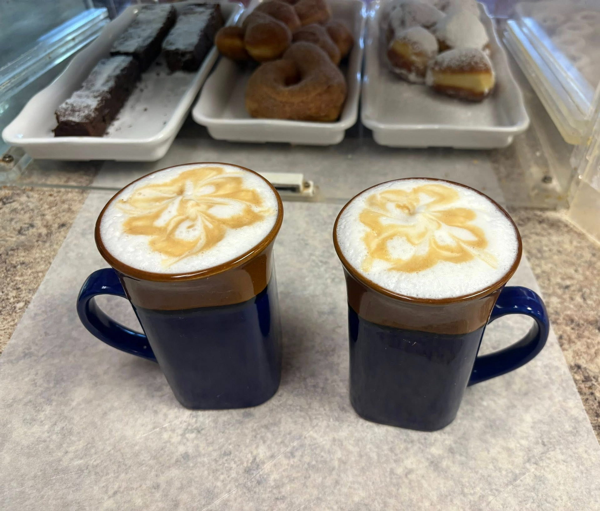Croissants with jam, coffee, and orange juice on a wooden tray for breakfast.