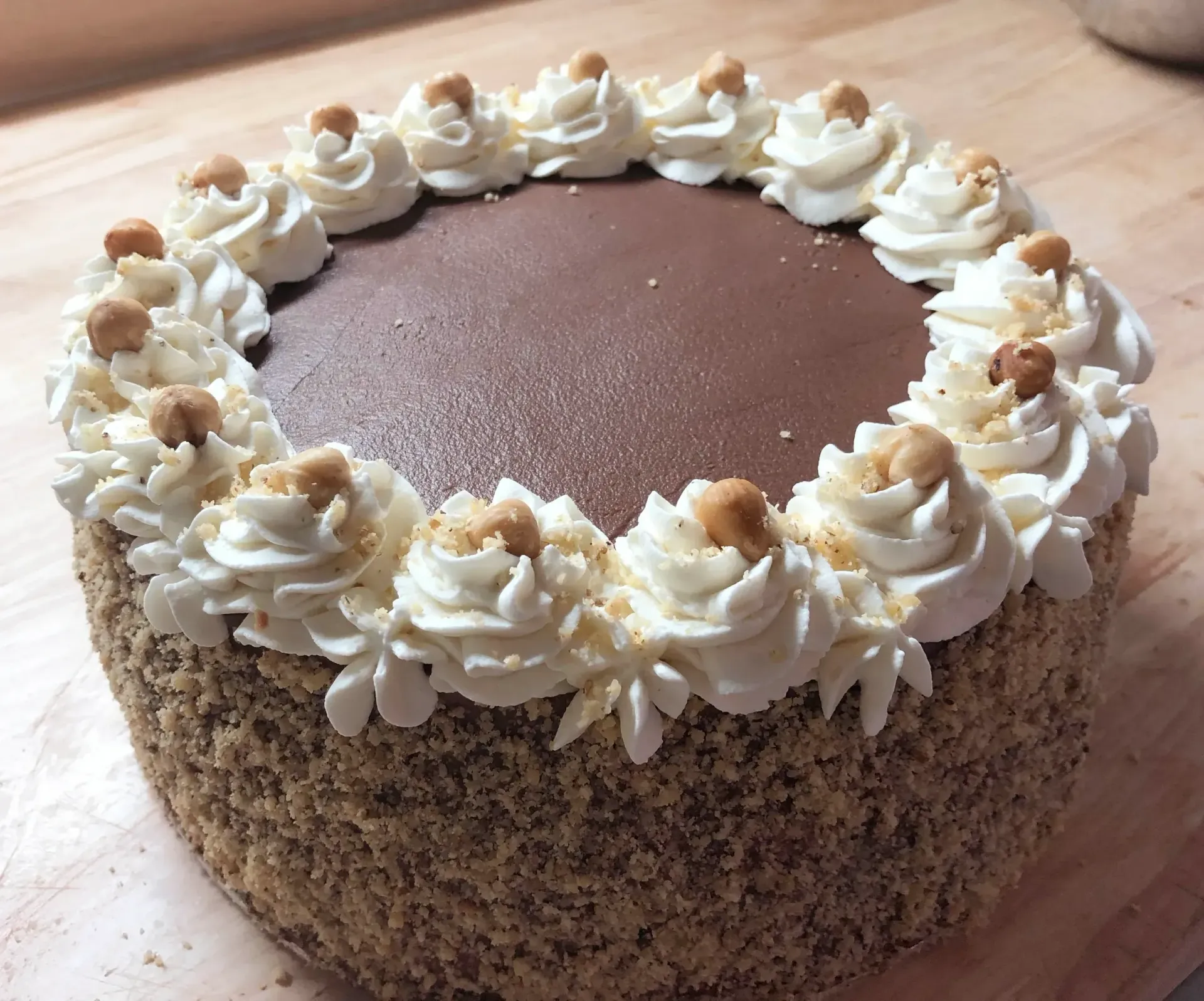 Chocolate cake with white frosting border and nuts.