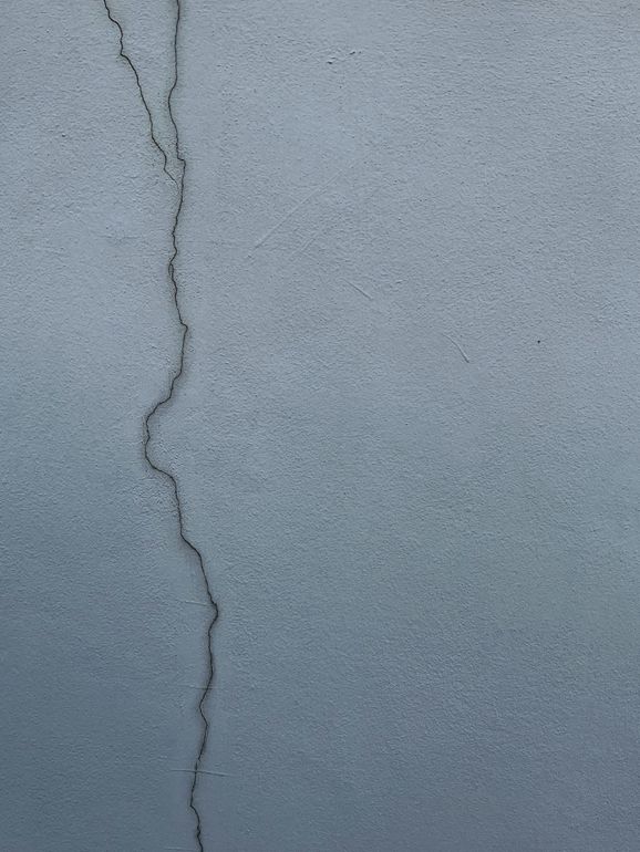 Gray wall with a vertical, winding crack running down the center.