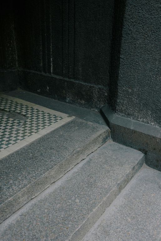 Granite steps and doorway with patterned tile floor.